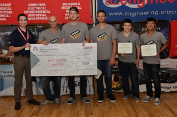 Team 16006 University students with presenter giving them a large award check