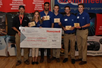 Team 16012 University students with presenter giving them a large award check