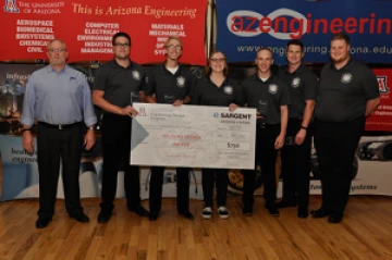 Team 16073 University students with presenter giving them a large award check