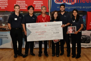Team 16043 University students with presenter giving them a large award check